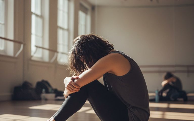 Katrina Patchett en pleine réflexion dans un studio de danse, symbole de son combat contre la boulimie.